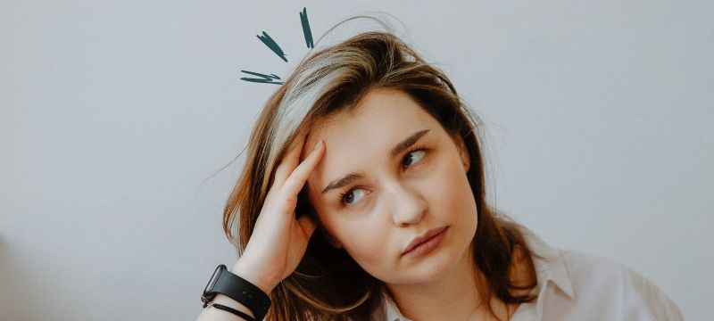 A woman sits with her head in her hand looking bored